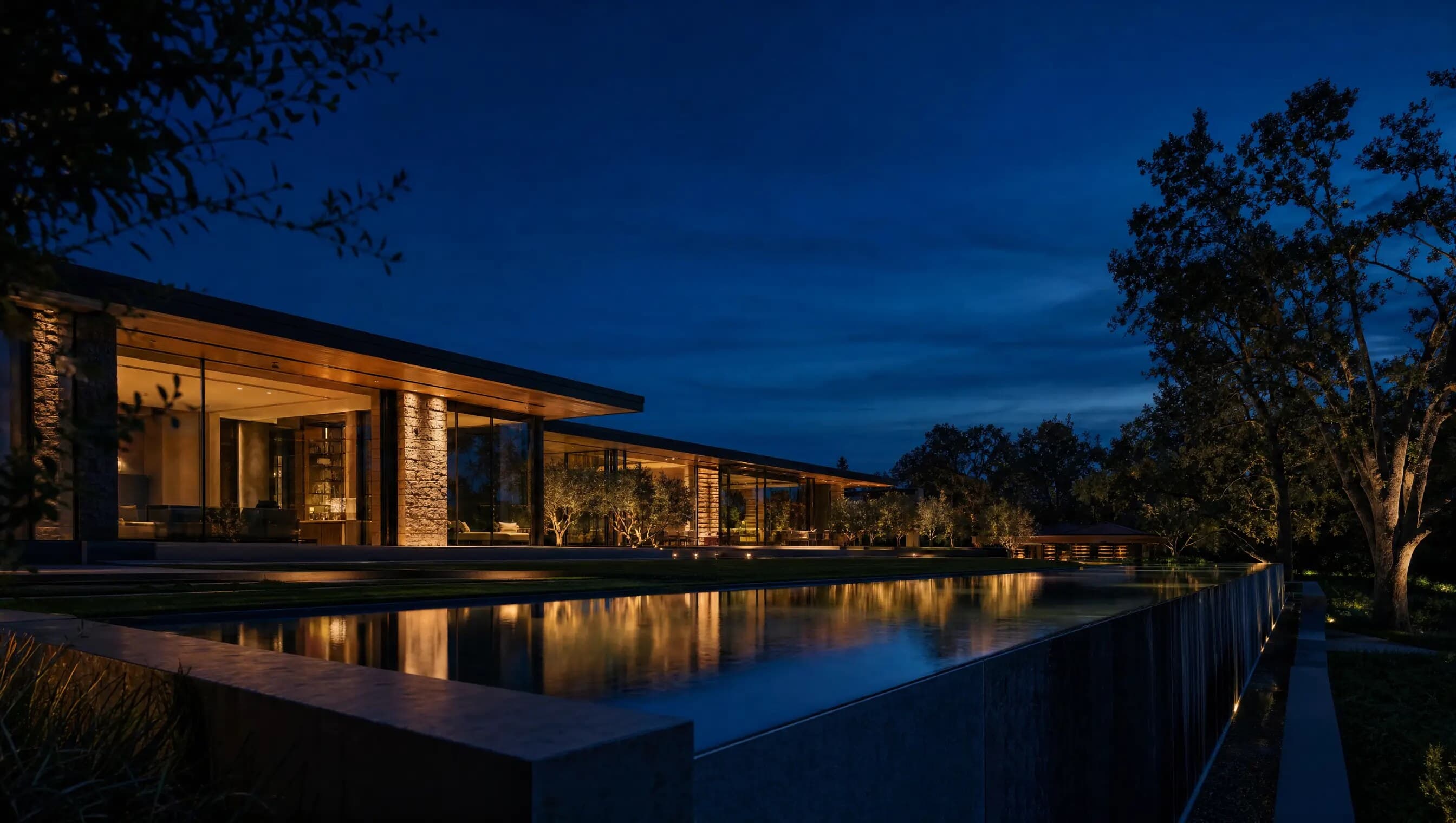 Modern home at blue hour with an infinity-edge water feature